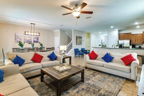 A spacious living room with two sofas, a coffee table, and a ceiling fan. - Game Room, Theater & More! Home 11 Mi to Disney (Davenport)