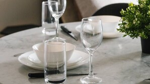 A round dining table with plates, glasses, and cutlery. - Modern Inner-City Stay in Valley|Heart of Brisbane (Fortitude Valley)