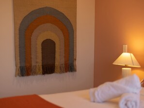 Ein Hotelzimmer mit einem Bett, einer Wandteppich und einer Nachttischlampe.