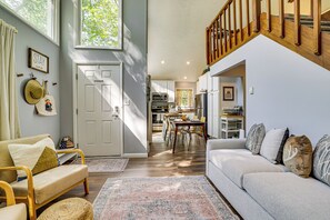 A spacious living area with a sofa, a dining table, and a kitchen in the background. - Outdoor Fun! Charming Family Home in Tobyhanna (Tobyhanna)