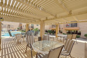 Eine Außenpatio mit Pool, überdachter Sitzgelegenheit und Blick auf das Gebäude.