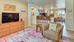 A living room with a TV, sofa, and patterned rug. - Pool Access! Extended Desert Escape Near St George (Washington)