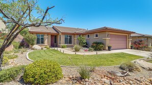 A residential house with a well-maintained lawn, a driveway, and a variety of landscaping including shrubs and rocks. - Pool Access! Extended Desert Escape Near St George (Washington)