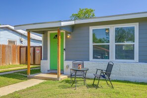 A residential house with a green door, a small patio with a table and chairs, and a window with blinds. - Central, Peaceful: 3 Mi to JBSA Lackland (San Antonio)