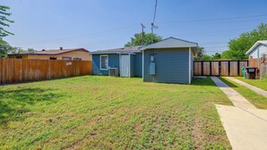 A residential property with a fenced yard, a small garage, and a house with a sloped roof.