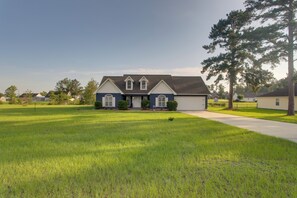 A two-story house with a front lawn, a driveway, and a large tree. - Peaceful Lake Escape w/ Dock in Coffee County (Douglas)