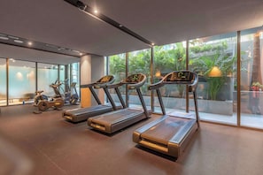 Ein Fitnessstudio mit Laufbändern, Fahrrädern und Trainingsgeräten.