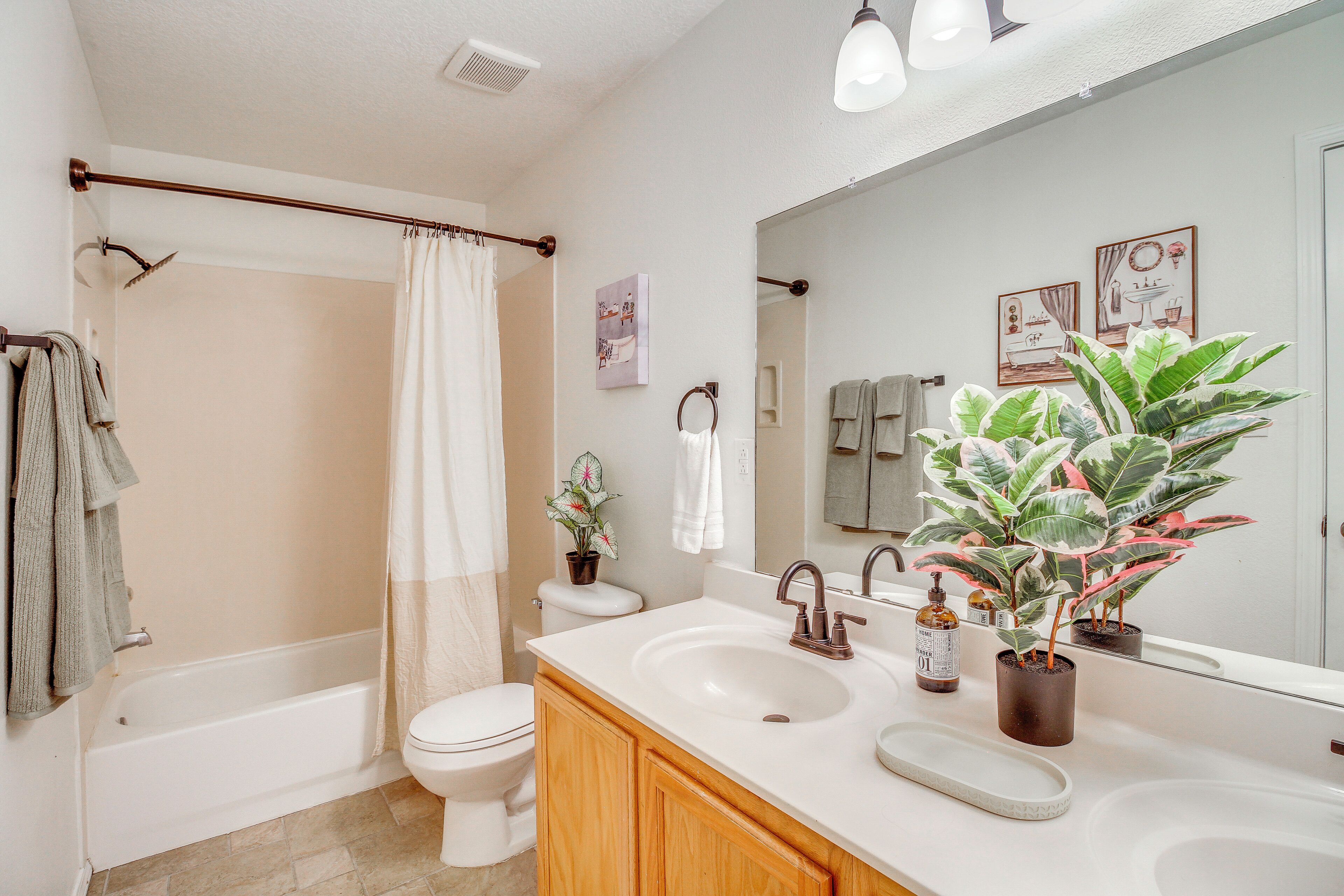 A bathroom with a bathtub, toilet, sink, and mirror.