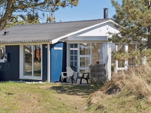 A small, single-story building with a dark blue exterior, a white door, and a window. - 4 Star Holiday Home in Thisted (Thisted)