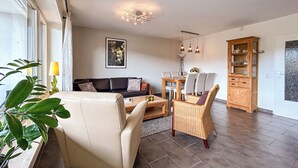 A living room with a sofa, chairs, a dining table, and a cabinet. - Cozy vacation apartment with a view, starting point for hikes, near Winterberg (Winterberg)