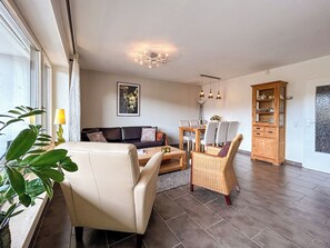 A living room with a sofa, chairs, a dining table, and a cabinet. - Cozy vacation apartment with a view, starting point for hikes, near Winterberg (Winterberg)