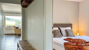 A bedroom with a bed, pillows, a bedside lamp, and a bench. - Cozy vacation apartment with a view, starting point for hikes, near Winterberg (Winterberg)