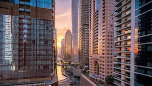 Un immeuble de grande hauteur, avec de nombreux étages, de grandes fenêtres et une rivière au premier plan.