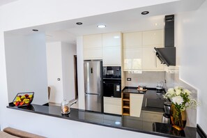 Una cocina moderna con refrigerador, horno y cafetera.