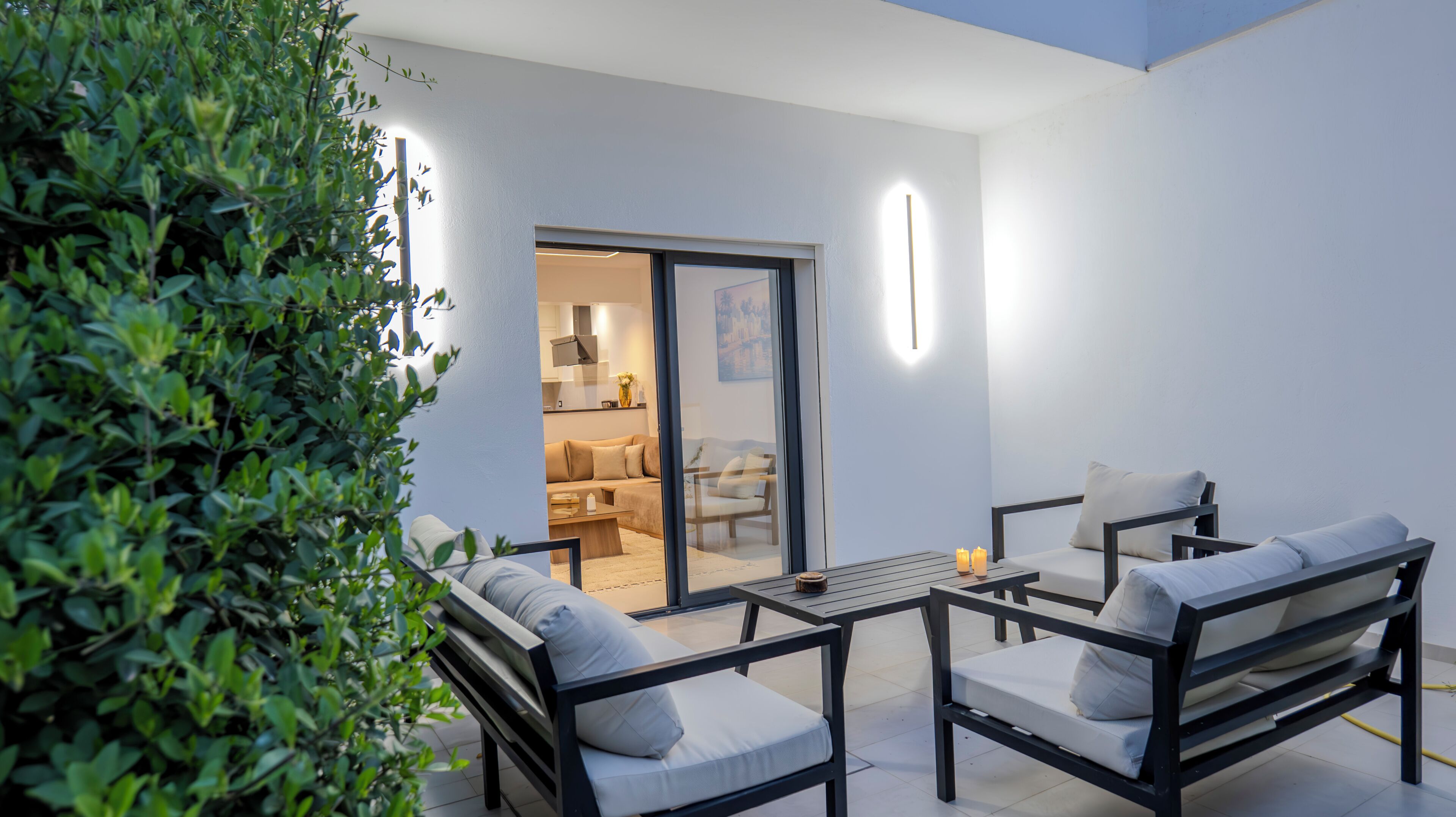 Une terrasse extérieure avec un canapé, des fauteuils et une table.