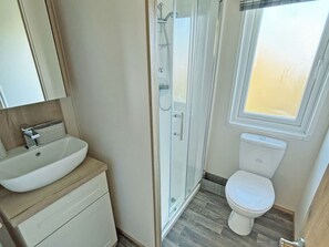 Ein Badezimmer mit Dusche, Toilette und Waschbecken.