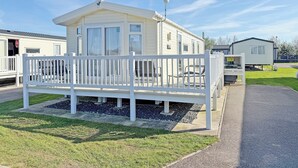 A mobile home with a porch, a covered outdoor seating area, and a small deck. - Skegness Fields 108 - UKC9566 (Skegness)