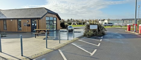 Een gebouw met een houten gevel, een picknicktafel en een bord.