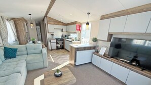 A modern living room with a sofa, a coffee table, and a TV. - Skegness Fields 108 - UKC9566 (Skegness)