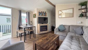 Una sala moderna con un sofá, una mesa de centro, un televisor y una chimenea.