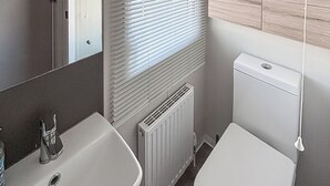 Um banheiro com pia, vaso sanitário e radiador.
