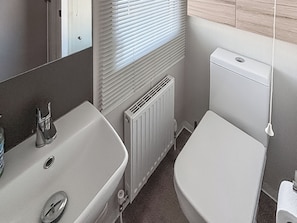 A bathroom with a sink, toilet, and radiator. - Sunnymede A6 - UKC9568 (Ingoldmells)