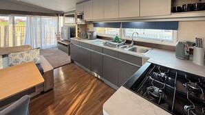 Uma cozinha moderna com fogão embutido, micro-ondas e pia.