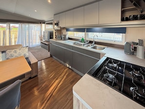 A modern kitchen with a built-in stove, a microwave, and a sink. - Sunnymede A6 - UKC9568 (Ingoldmells)
