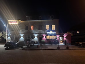 Um edifício com uma placa indicando 'DÖNERKING' e um carro estacionado na frente.