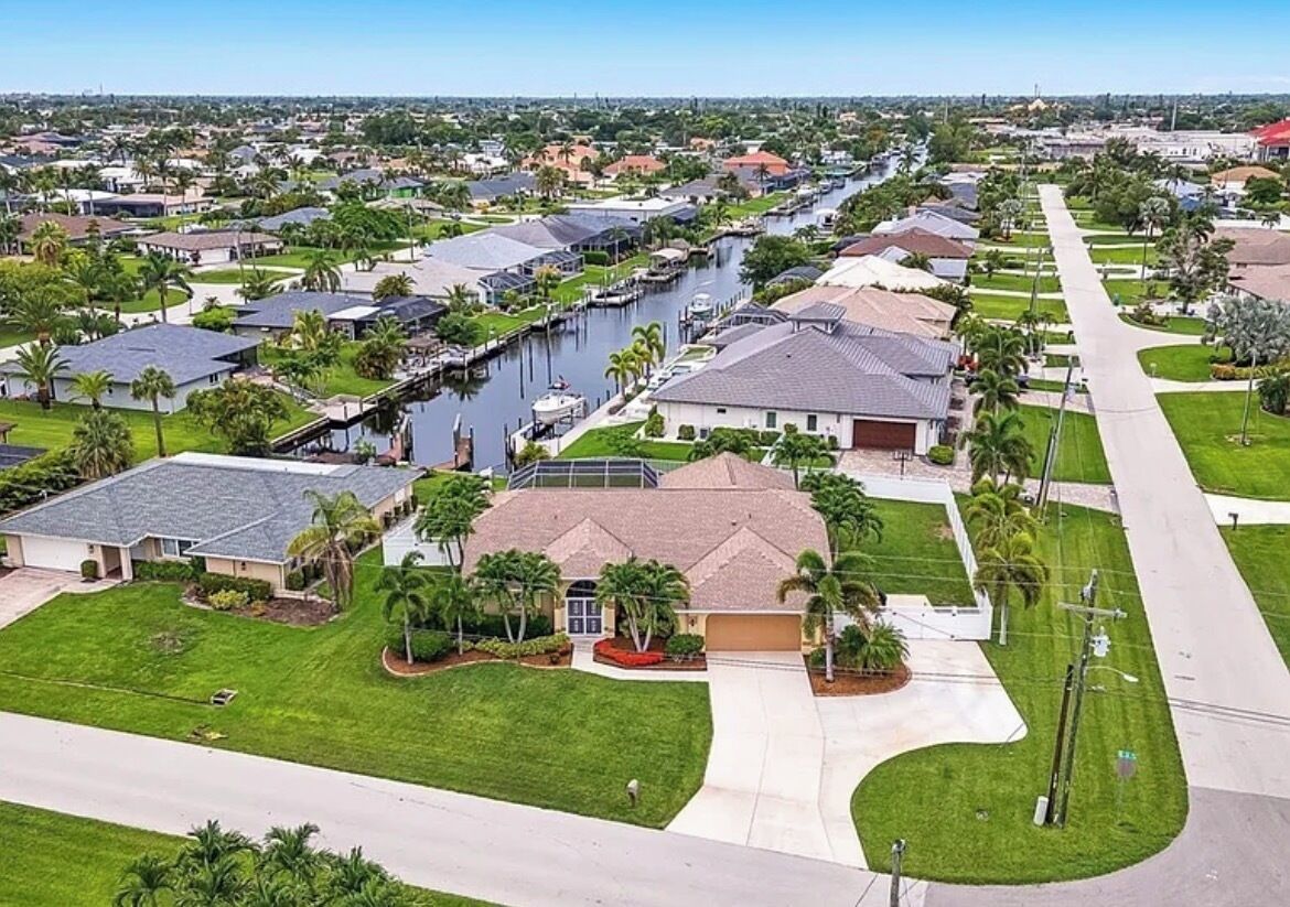 Un quartiere residenziale con case, un canale e cielo sereno.