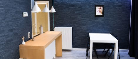 A modern kitchen with a wooden counter, white table, and pendant lights.