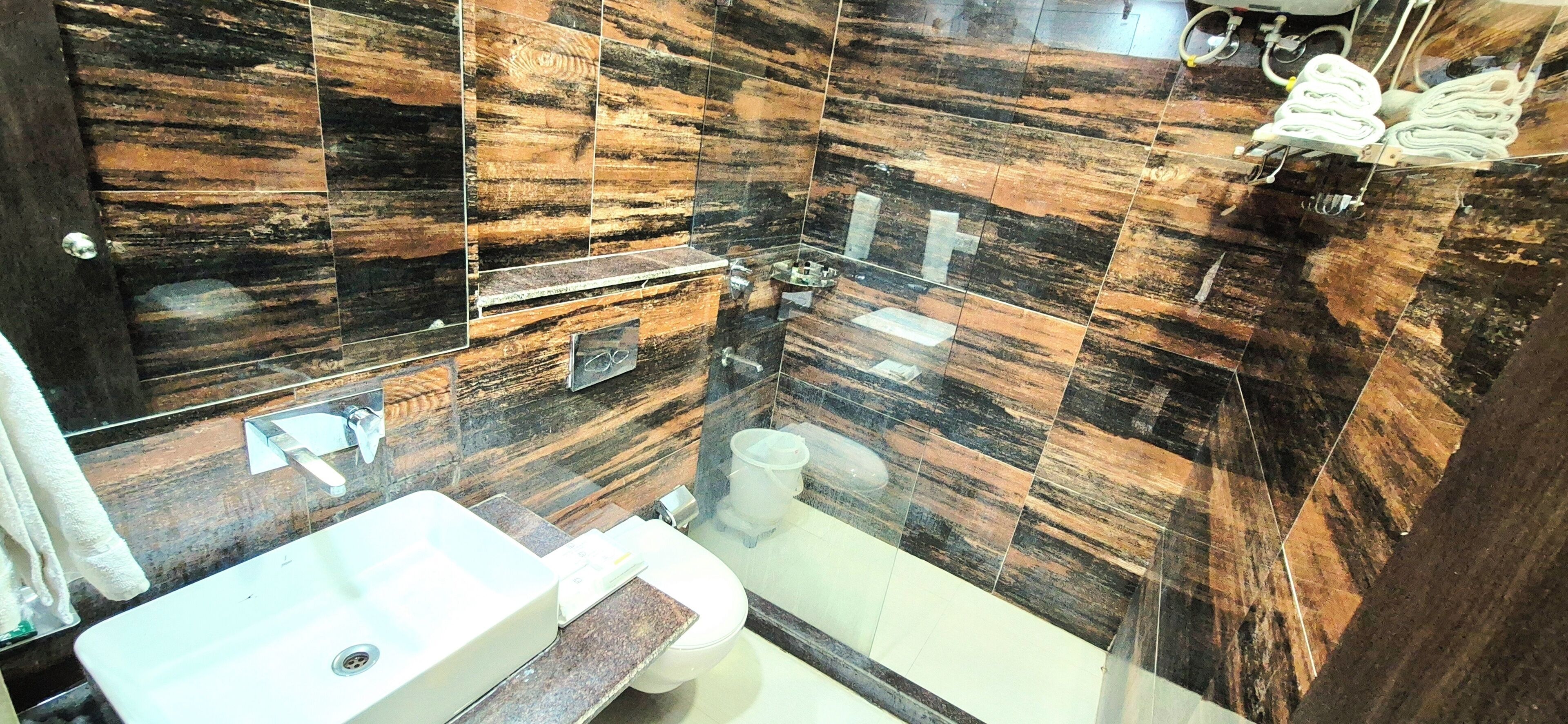 A bathroom with a sink, toilet, and shower area.