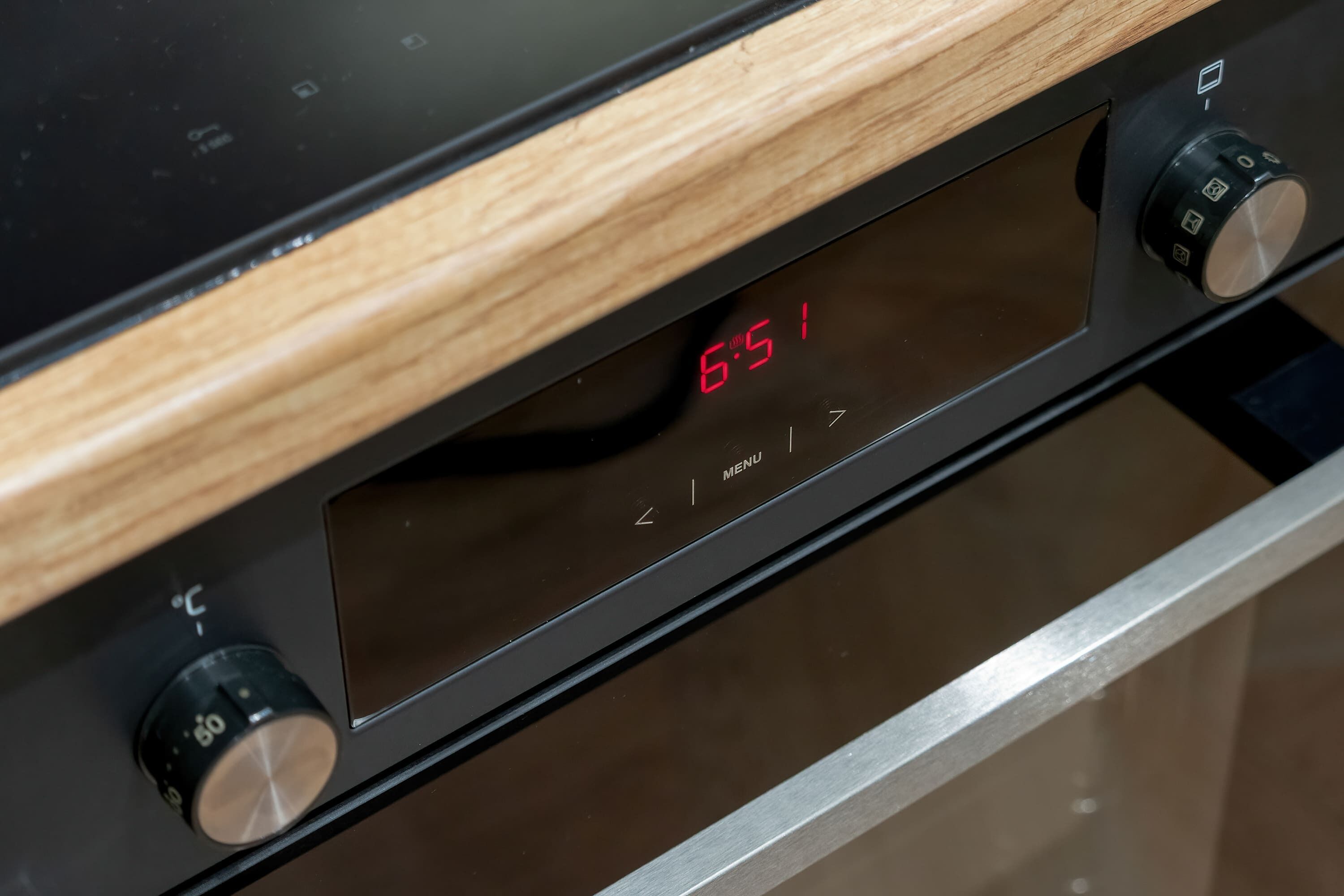 A digital display with a wooden panel and control knobs.