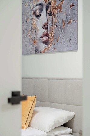 A bedroom with a bed, pillows, and a wall-mounted artwork. - Charming Apartment with a Terrace | Pets Welcome (Łódź)