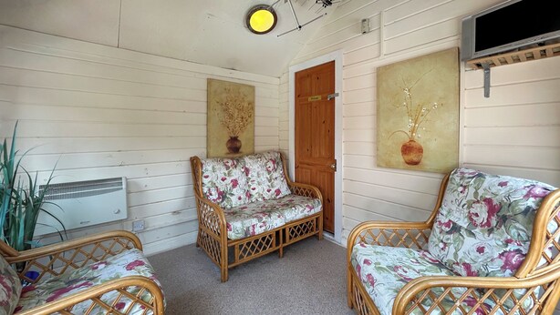 A room with wicker furniture, a door labeled 'Private,' and a wall-mounted air conditioner.
