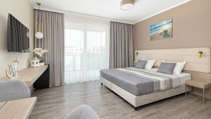 Une chambre d’hôtel moderne avec un grand lit, un bureau et une vue sur la ville.