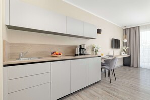 Eine moderne Küche mit integriertem Spülbecken, einer Kaffeemaschine und einer Obstschale.
