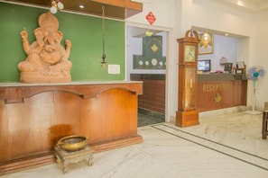 Un comptoir d’accueil avec un revêtement en bois, une horloge et un ventilateur.