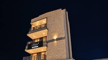 A multi-story building with balconies and a sign that reads 'Café'.