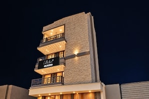 A multi-story building with balconies and a sign that reads 'Café'.
