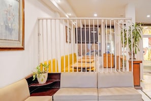 A modern interior with a sofa, a staircase, and a view of the street. - Classic Siliguri Maple (Bhubaneshwar)