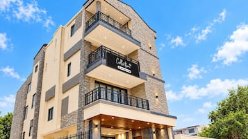 Un immeuble à plusieurs étages, sur lequel on peut lire une enseigne indiquant qu’il s’agit d’un appartement avec services.