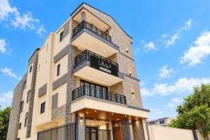 A multi-story building with a sign indicating it is a serviced apartment.