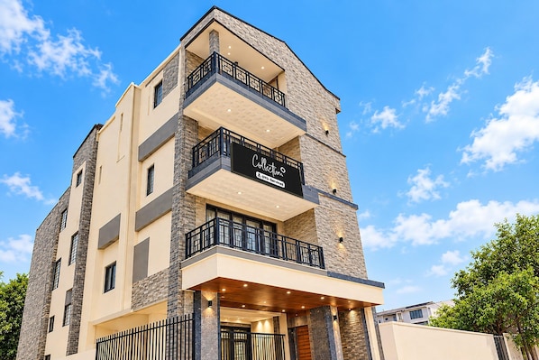 A multi-story building with a sign indicating it is a serviced apartment. - Classic Siliguri Maple (Bhubaneshwar)