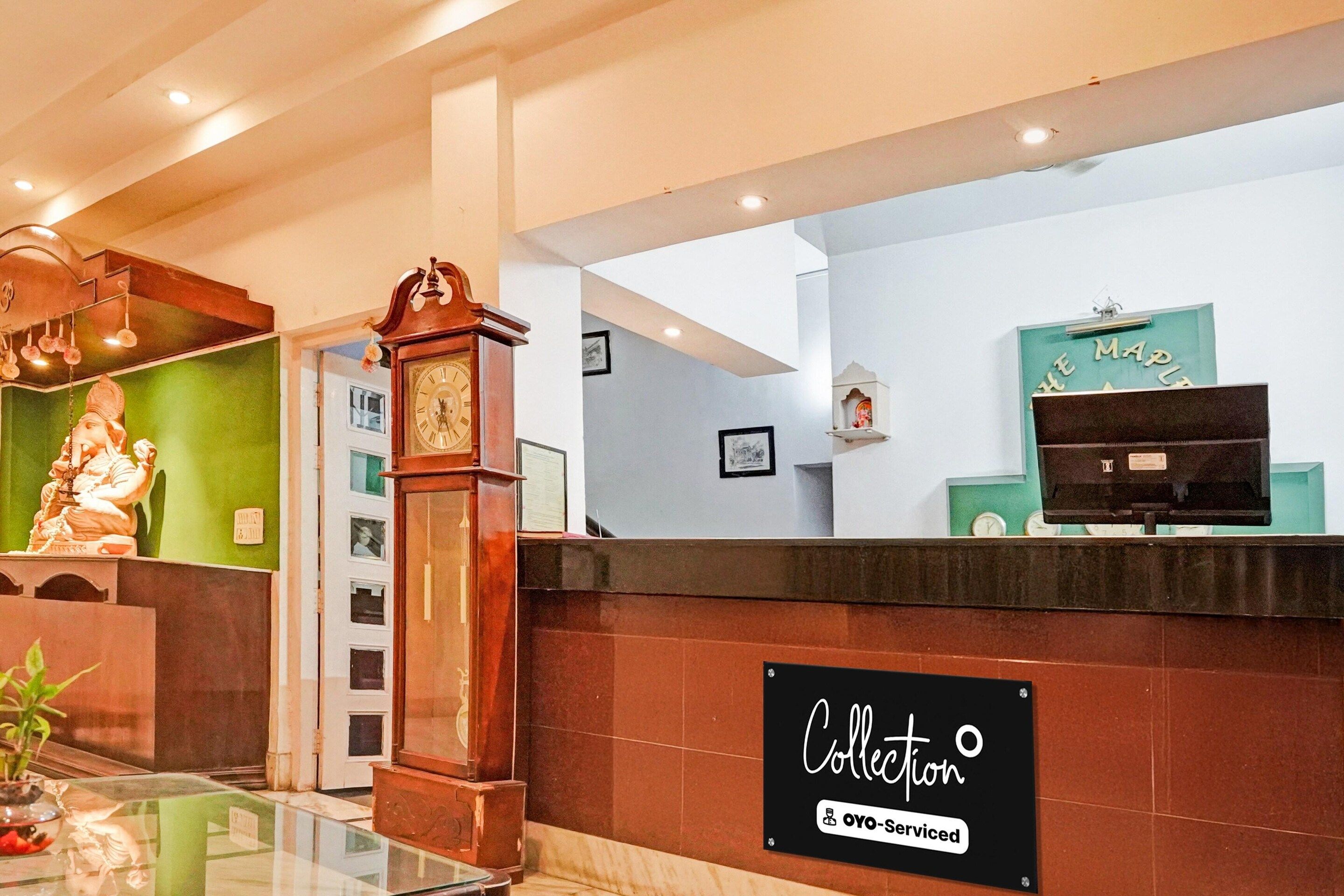 A reception area with a clock, a statue, and a sign indicating a collection service.