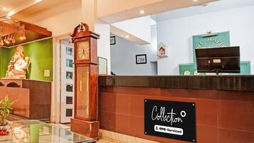 A reception area with a clock, a statue, and a sign indicating a collection service.