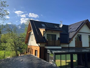 A modern house with a sloped roof, solar panels, and a satellite dish. - Vila DEDO (Vysoké Tatry)