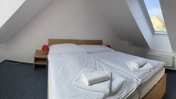 Een kamer met een bed, een bureau, een televisie en een raam.