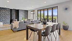 Una sala de estar moderna con sofá, mesa de comedor y chimenea.