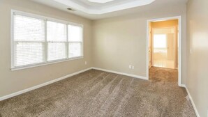 A room with a carpeted floor, a ceiling with a recessed light, and a door leading to another room. - Spacious Brick Home in Acworth – Perfect Family Getaway (Acworth)